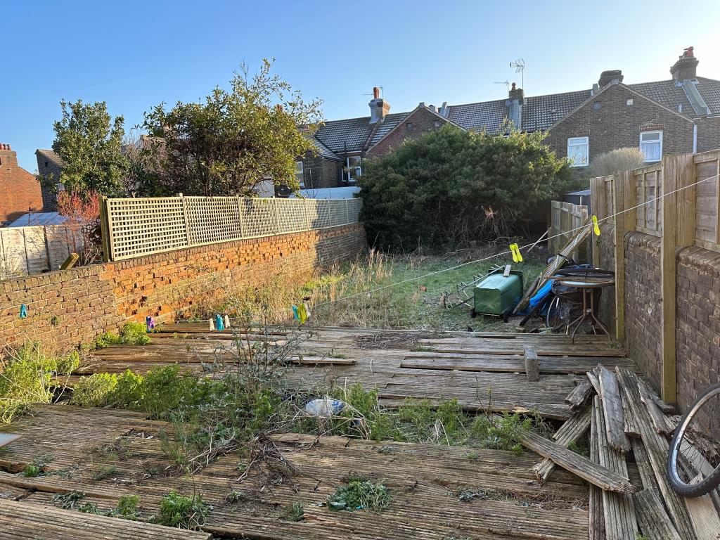 Lot: 91 - SIX-BEDROOM SEMI-DETACHED HOUSE CURRENTLY ARRANGED AS A HMO - Back garden of the property with slight damaged decking